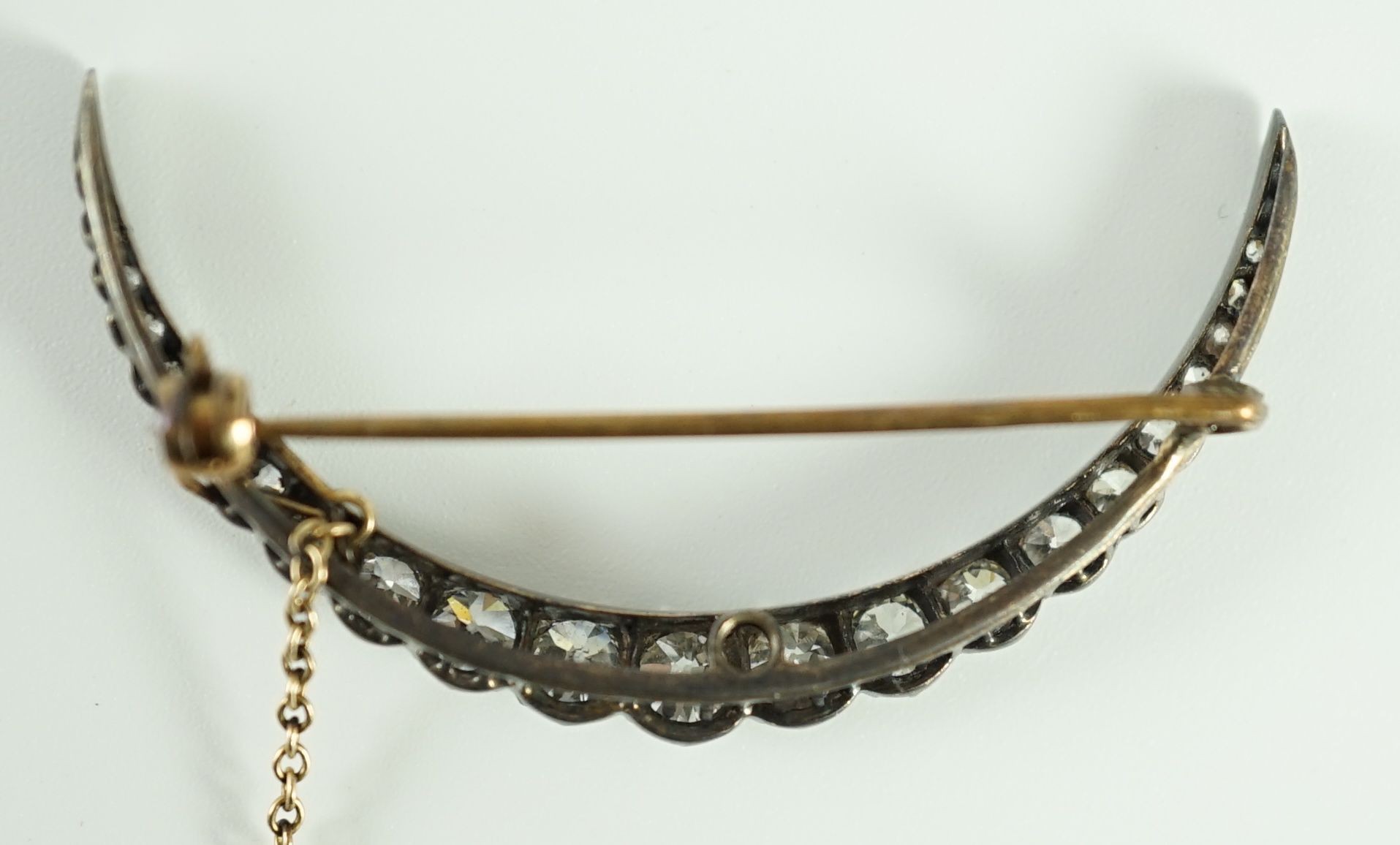 A Victorian, gold, silver and graduated twenty one stone diamond set crescent brooch
